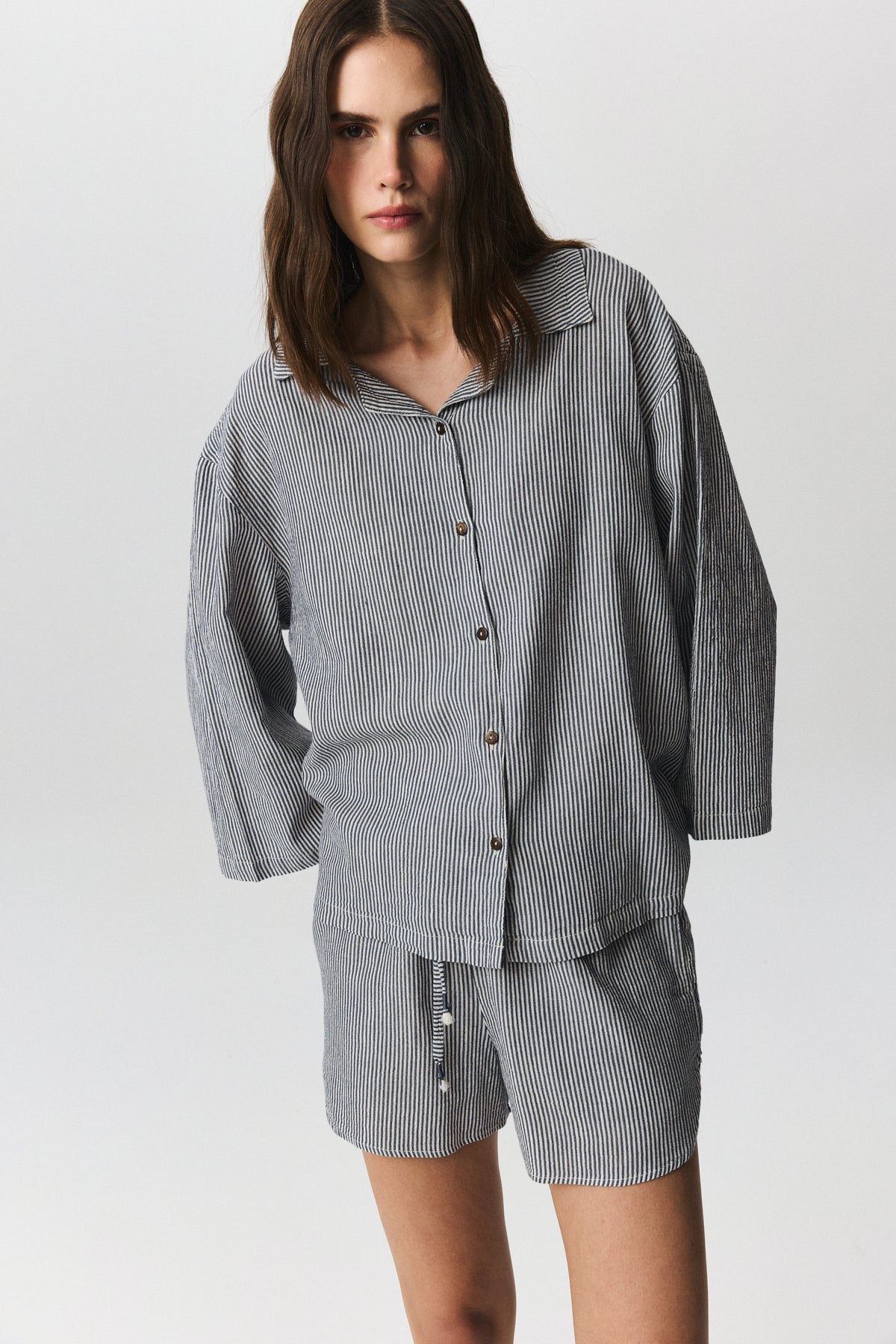 Nina shirt with fine stripes and coconut shell buttons, draped casually