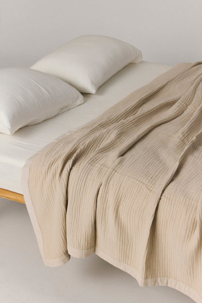 Zen muslin bed cover with layered texture and cotton framed edges