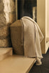 Anvers wool throw with two-tone design and fringed edges on armchair