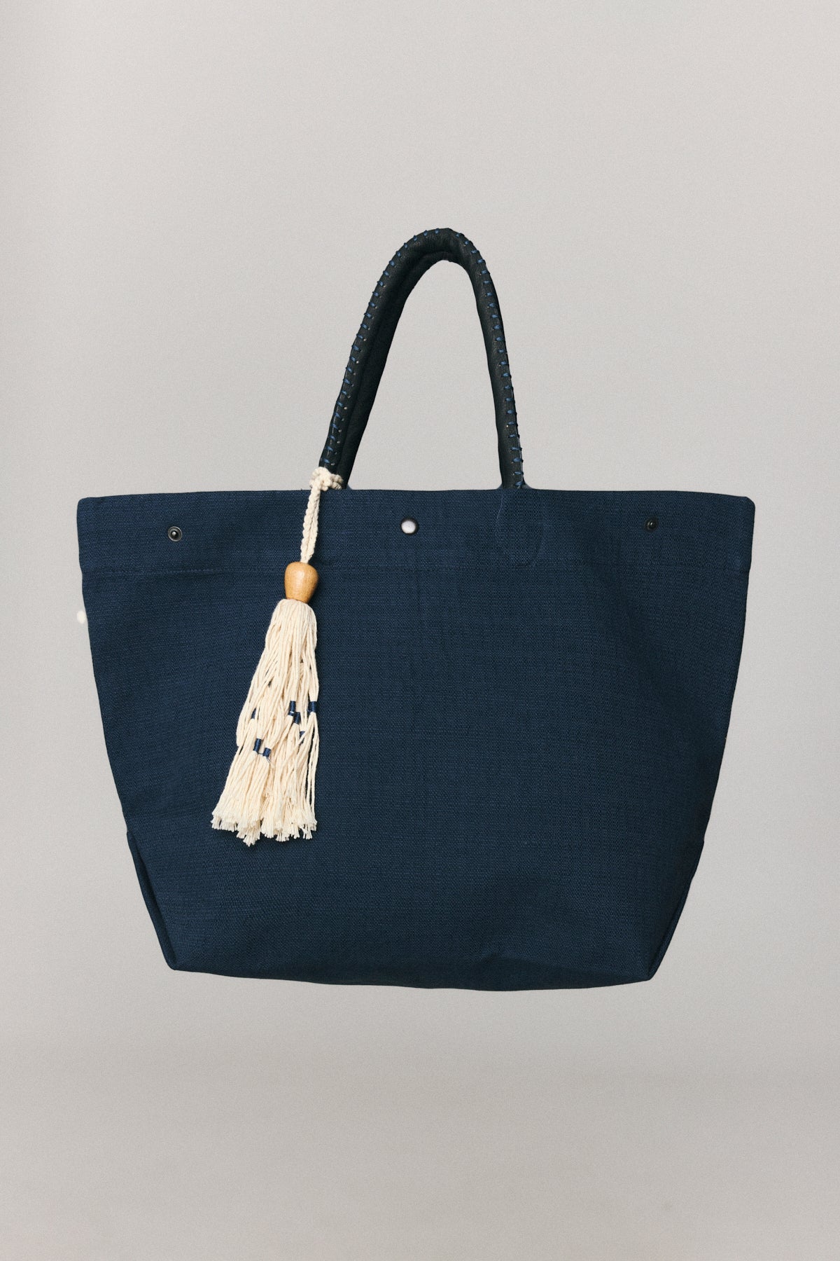 Atelia linen shoulder bag with braided handles and wooden tassel detail