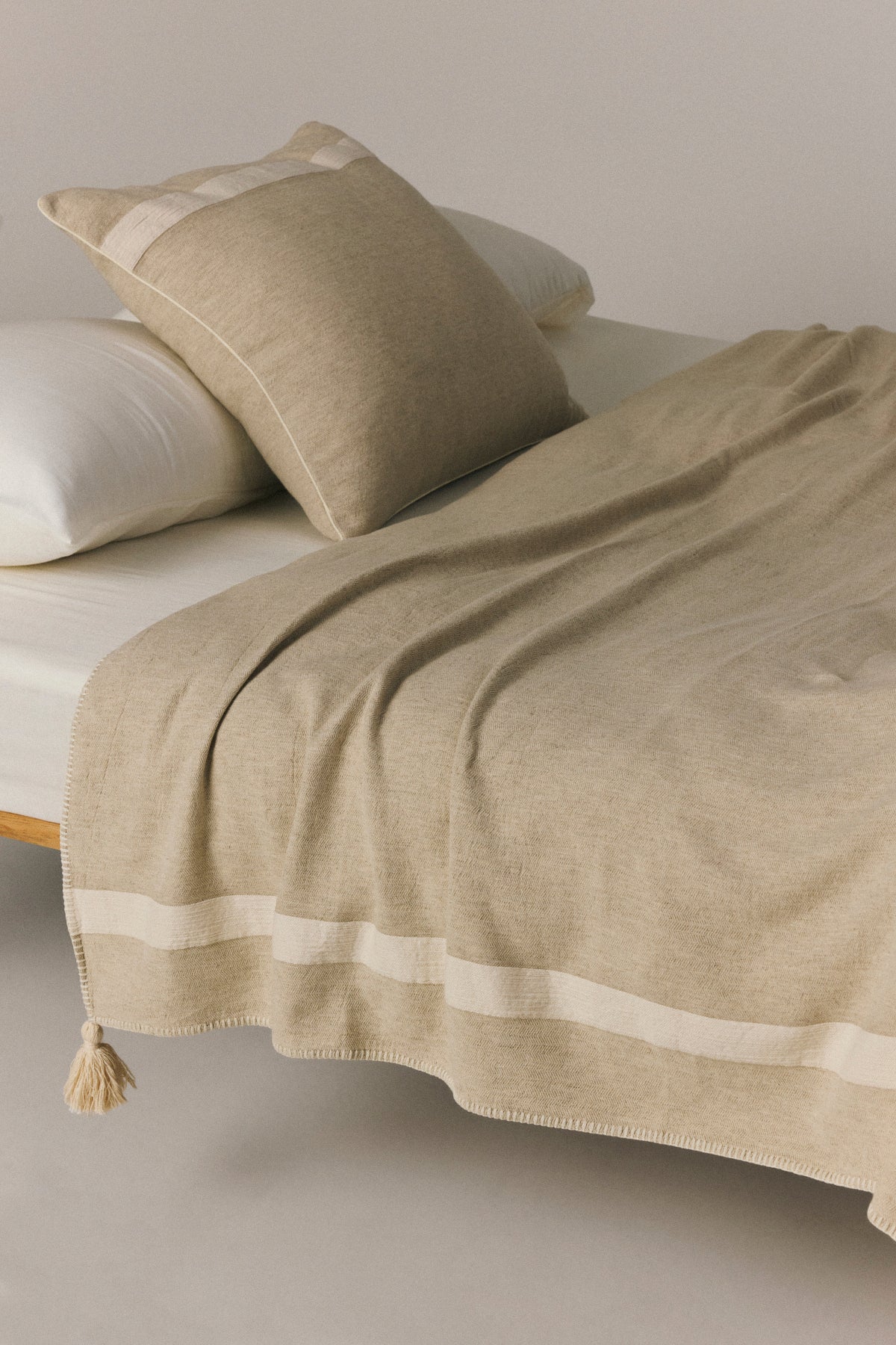 Pirene throw blanket with handcrafted pompom details and topstitching