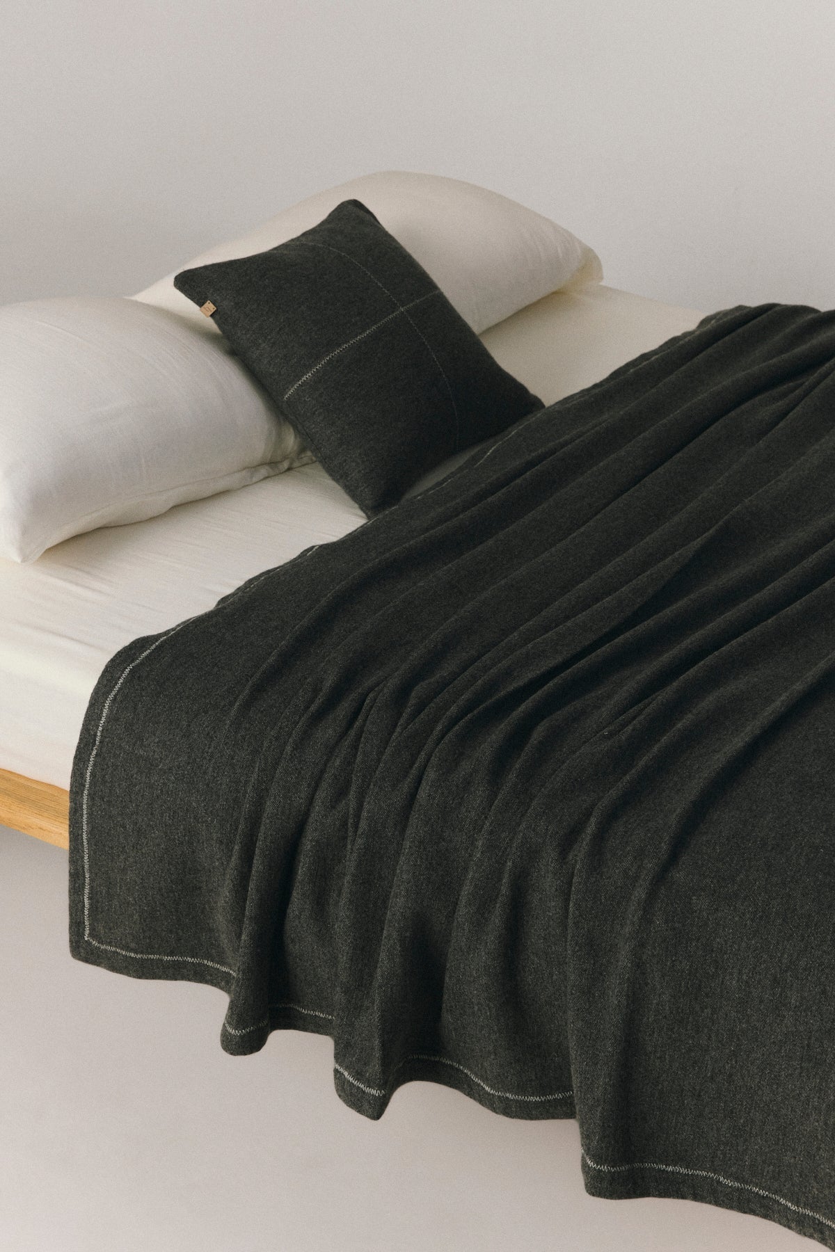 Talin wool bed cover with zigzag topstitch detail, reversible design in neutral tones