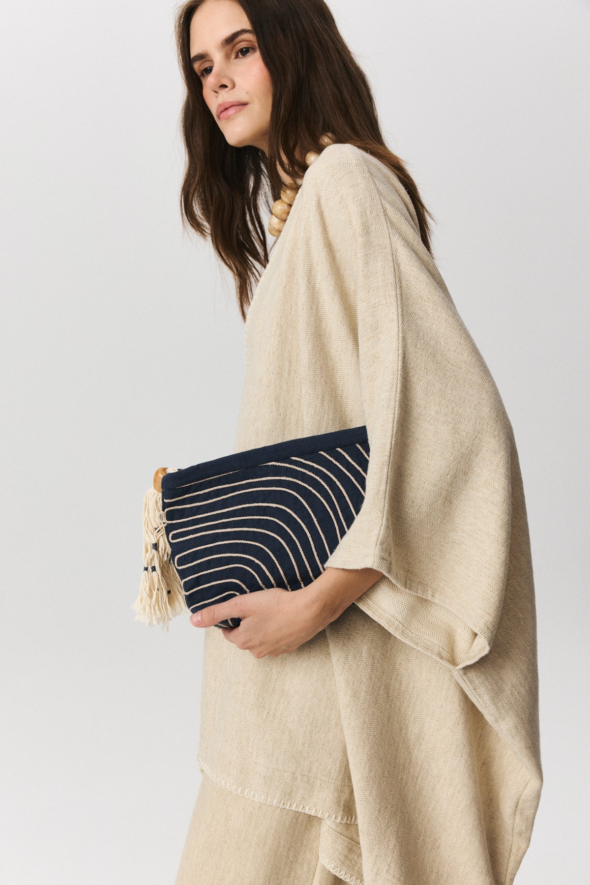 Wave embroidered linen clutch bag with wooden bead tassel detail